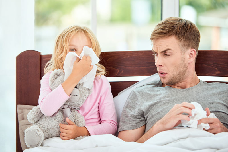 bolesna devojčica i tata leže u krevetu zbog oslabljenja imunog sistema